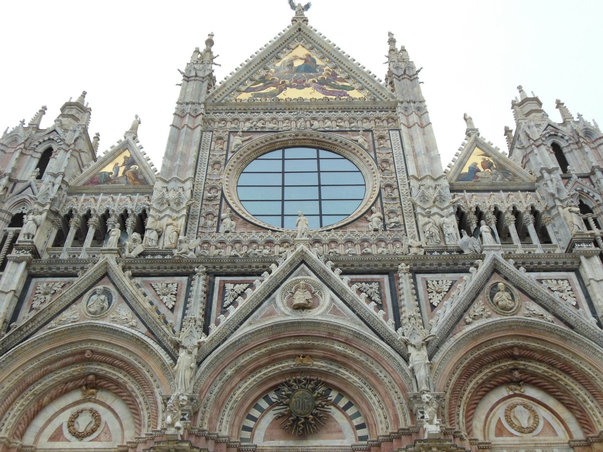 The front of a large church with a large round window.