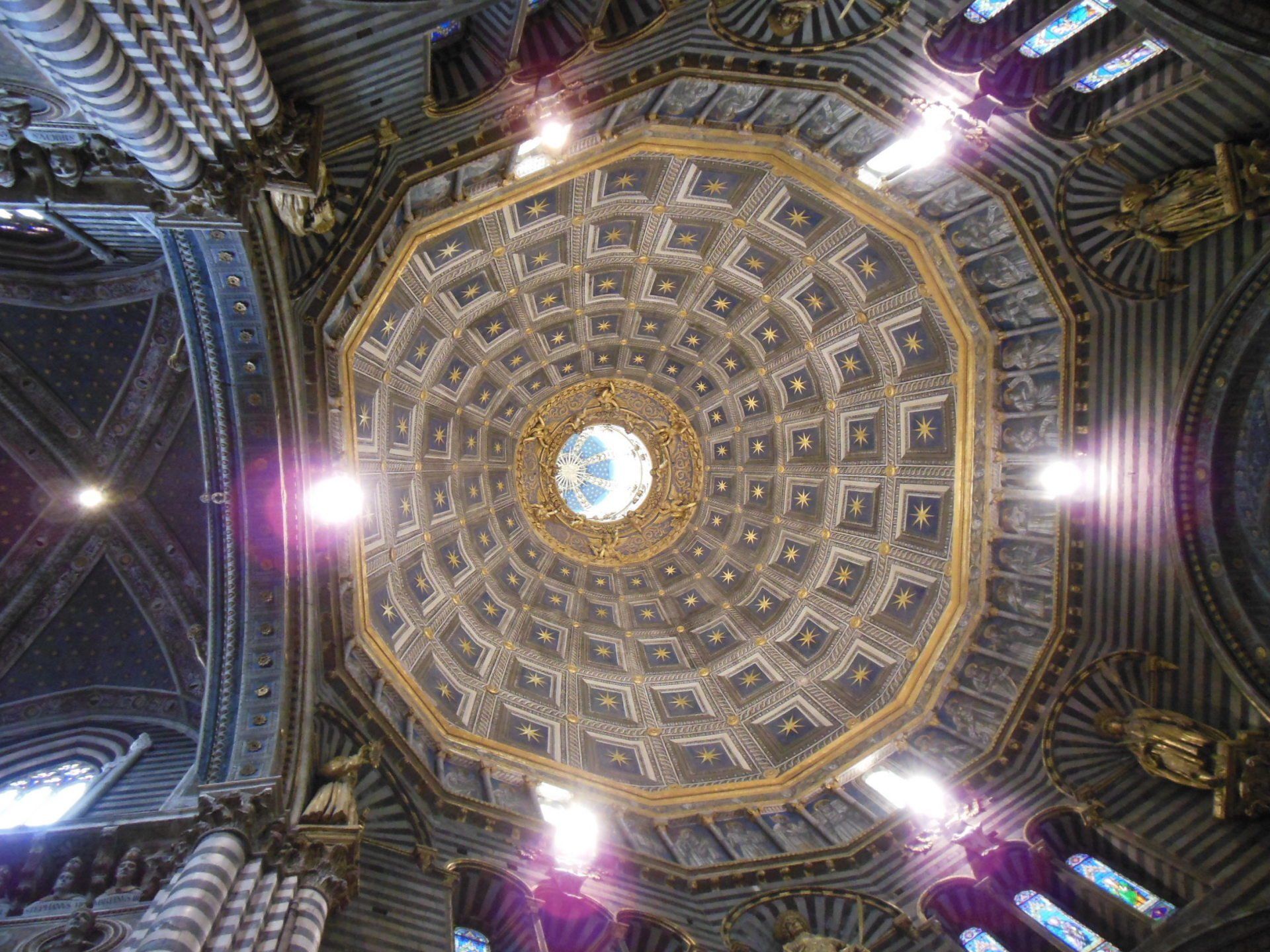Looking up at the dome of a church with stained glass windows