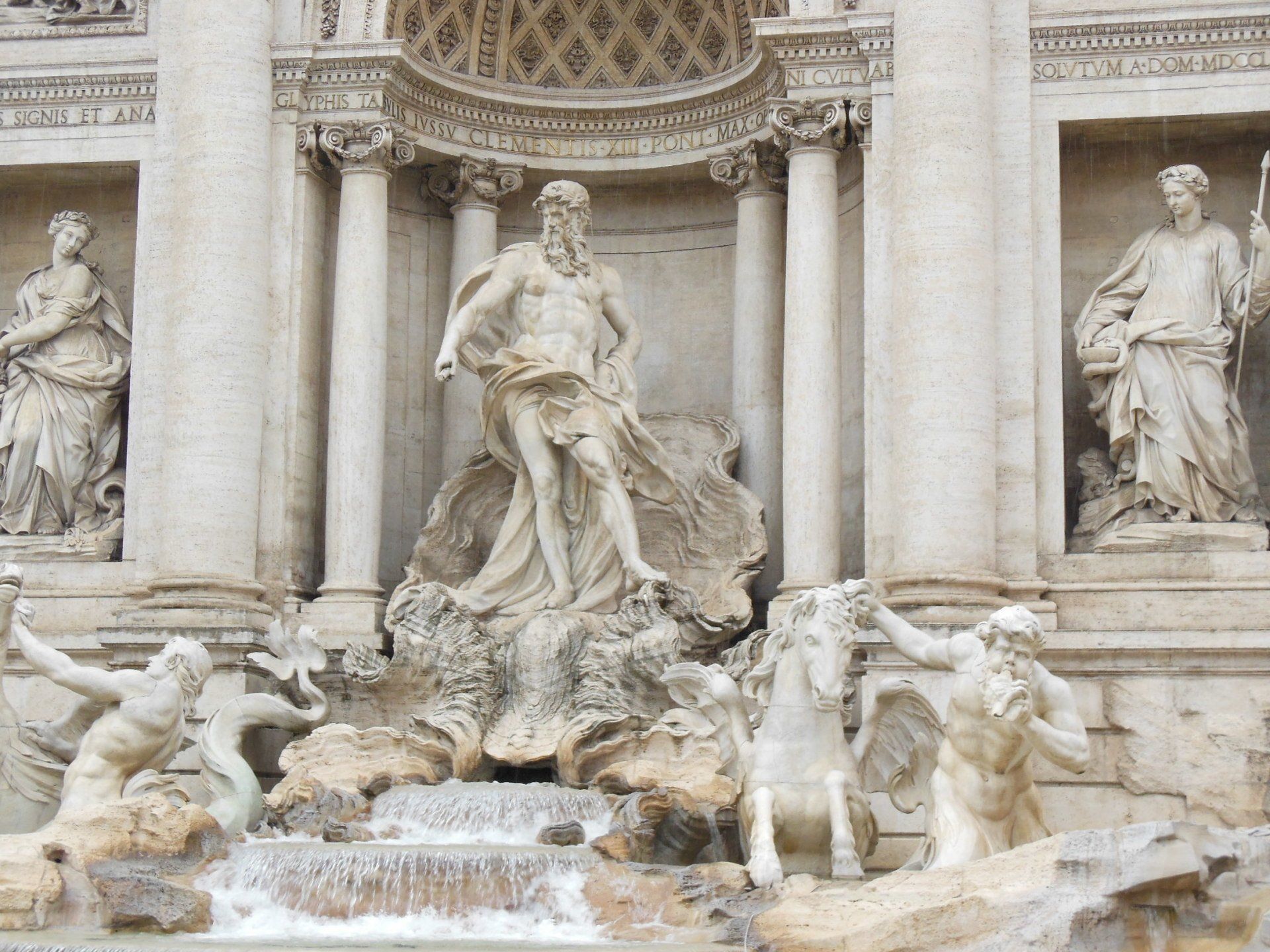 A statue of a man standing next to a horse in front of a building
