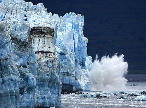 A large iceberg is breaking into the ocean.