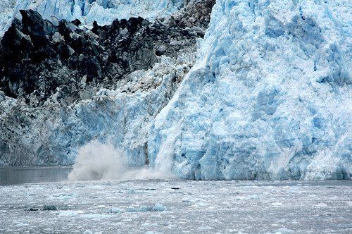 A large iceberg is breaking into the ocean.
