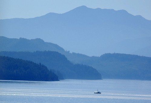 A boat is floating on a lake with mountains in the background.