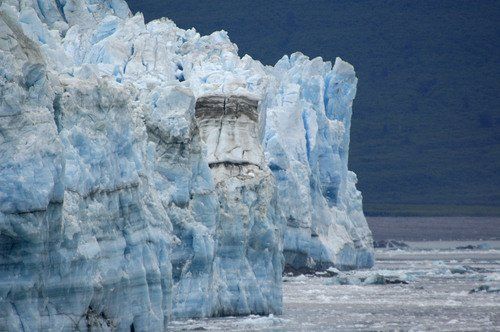 A large iceberg is sitting in the middle of a body of water.