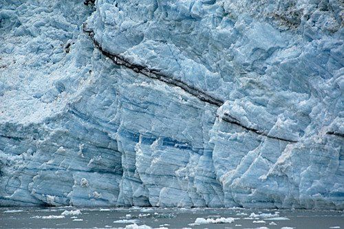 A large iceberg is sitting in the middle of a body of water.