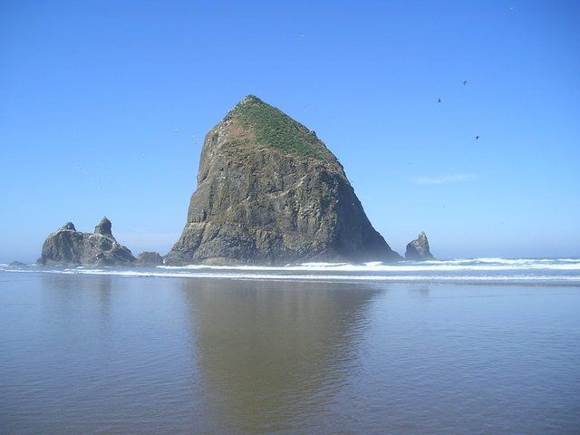A large rock sitting on top of a body of water