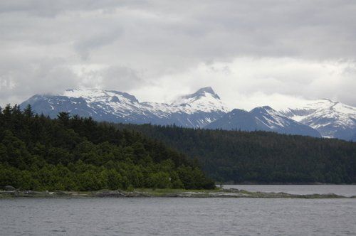 A lake with mountains in the background and trees on the shore