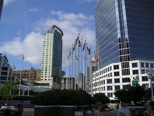 A group of people standing in front of a row of tall buildings