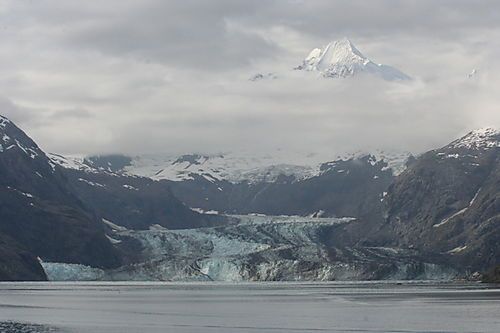 A large body of water surrounded by snow covered mountains