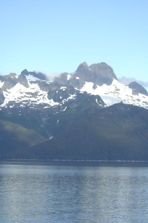 A lake with mountains in the background and a blue sky