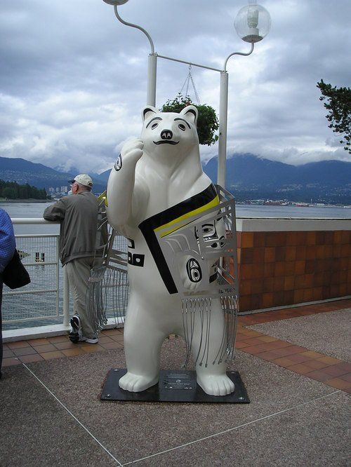 A statue of a polar bear holding a newspaper