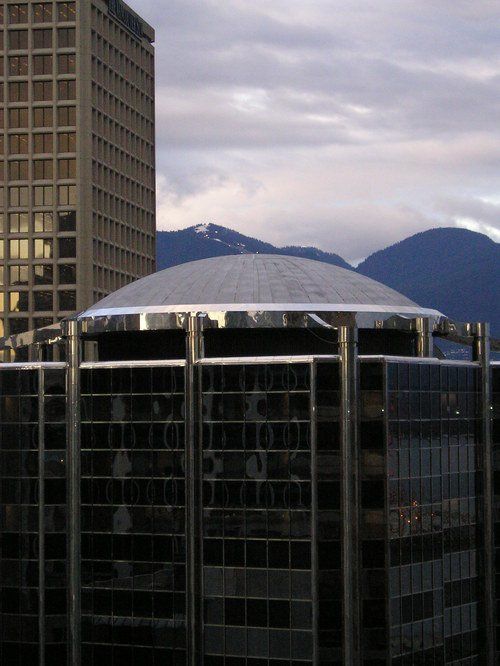 A building with a dome on top of it and mountains in the background