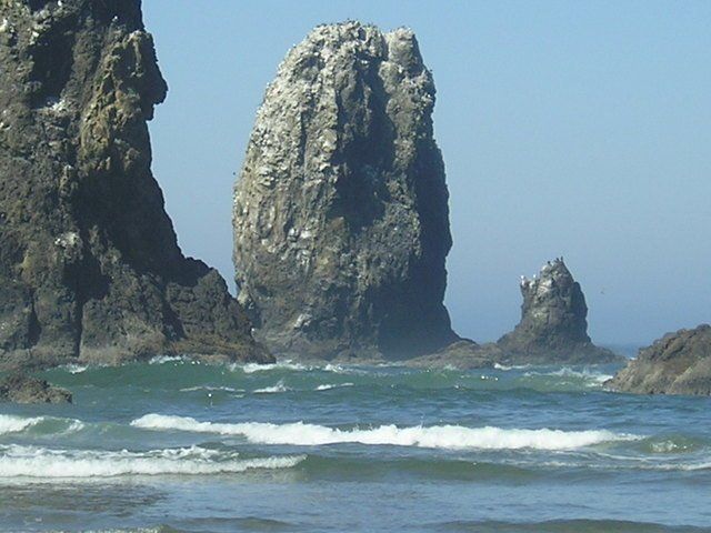 A large rock in the middle of a body of water