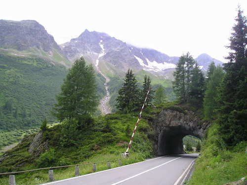 A road going through a tunnel with mountains in the background