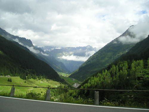 A road going through a valley with mountains in the background