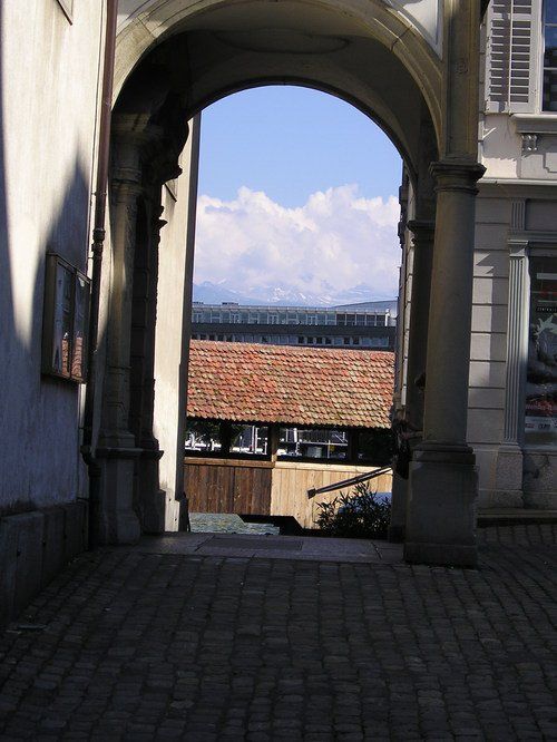 An archway leading to a building with a view of mountains