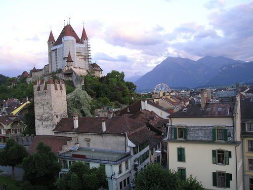 A castle sits on top of a hill overlooking a city