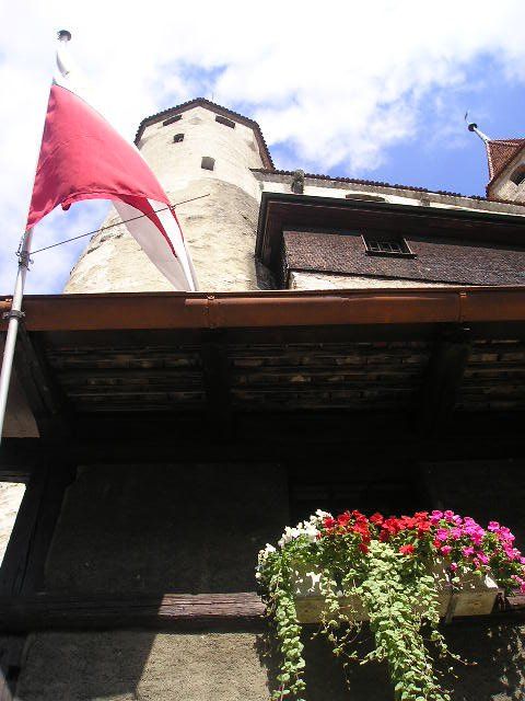 A red and white flag is flying in front of a building