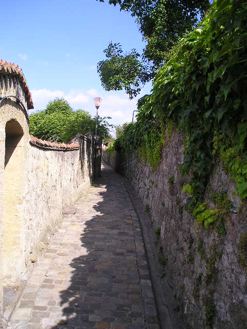 A brick walkway with a stone wall on both sides