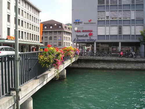 A bridge over a river with a building in the background.
