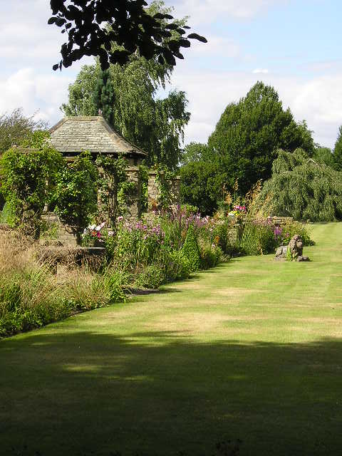 A gazebo in the middle of a lush green field