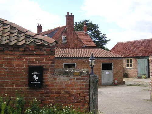 A brick wall with a mailbox on it in front of a brick building.