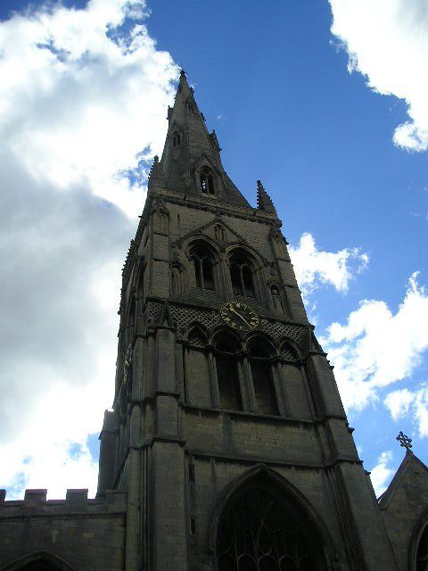 A clock tower with a blue sky and clouds behind it