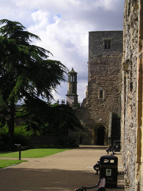 A large stone building with a clock tower in the background