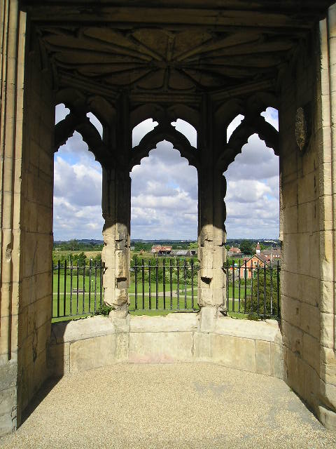 A stone building with arches and a view of a field