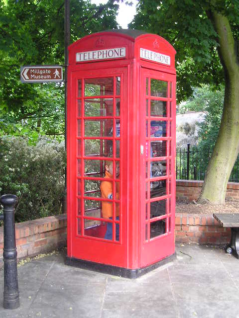 A red telephone booth with the word telephone on it