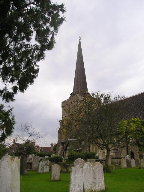 A church with a steeple and graves in front of it