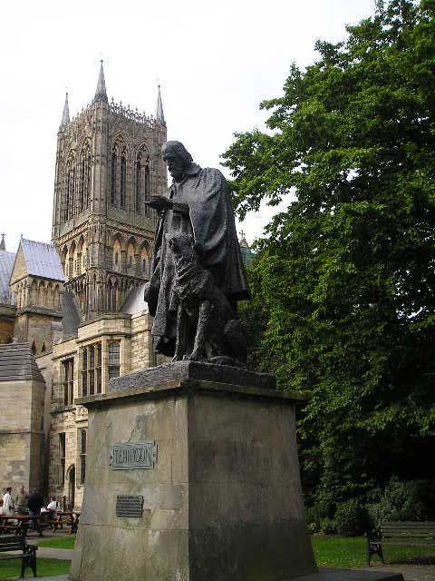 A statue of a man with a dog in front of a cathedral