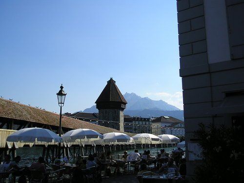 A group of people sitting under umbrellas in front of a building