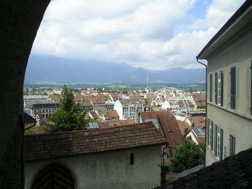A view of a city from a building with mountains in the background