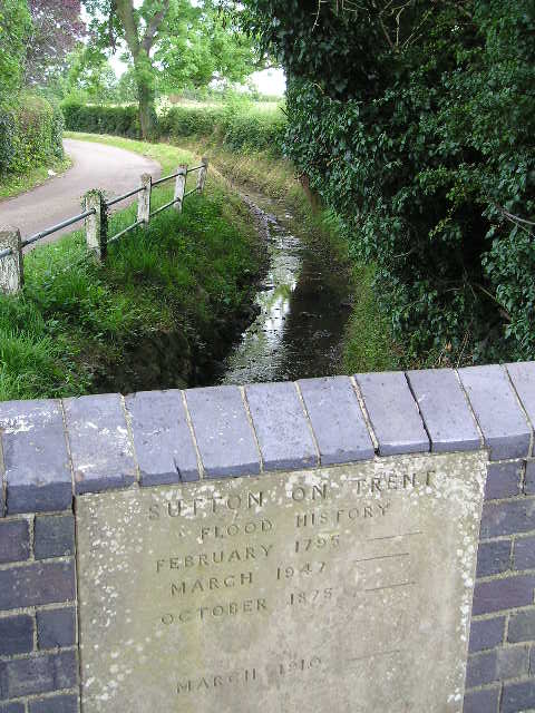 A brick wall with a plaque that says ' flood history ' on it