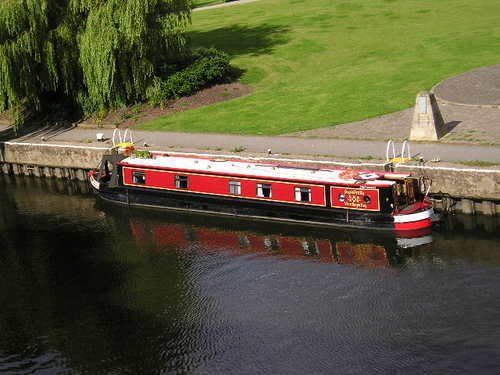 A red boat is floating on a body of water
