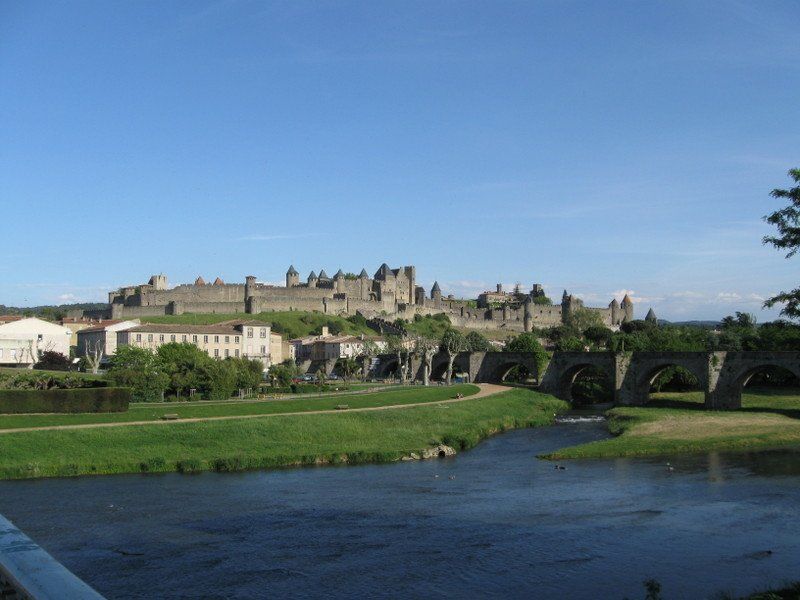 A bridge over a river with a castle in the background