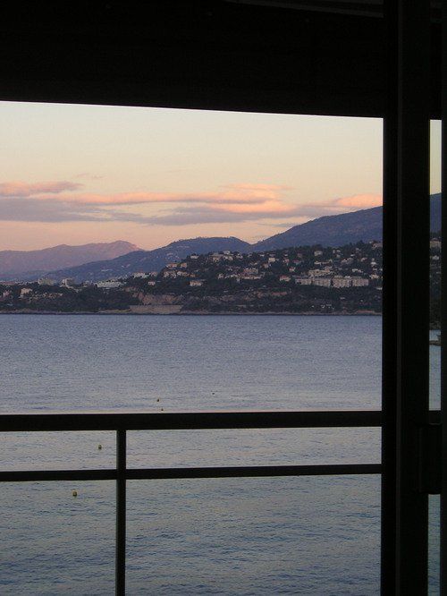 A balcony overlooking a body of water with mountains in the background