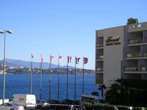 A row of flags are lined up in front of a building that says ' flamingo ' on it