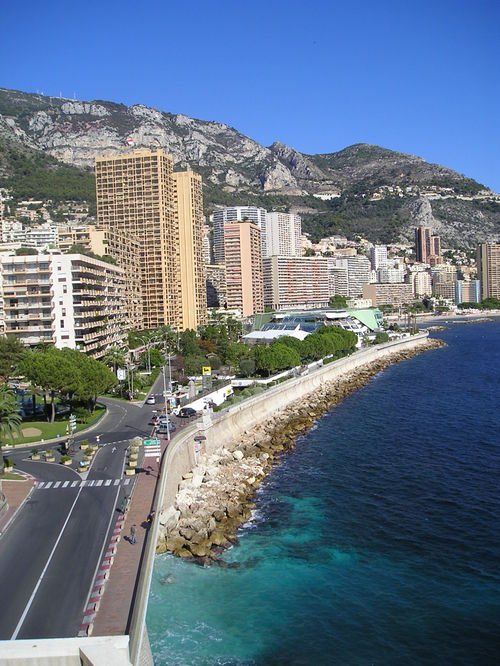 An aerial view of a city near the ocean with mountains in the background