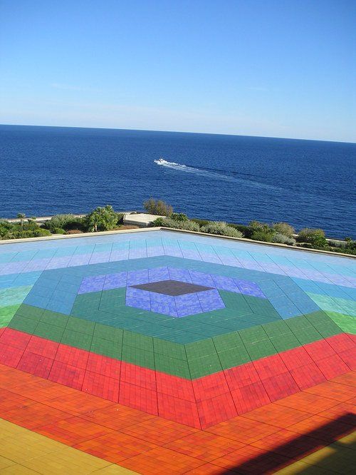 A rainbow colored floor with the ocean in the background