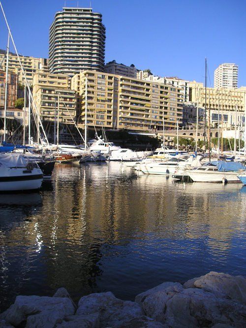 Boats are docked in a harbor with buildings in the background