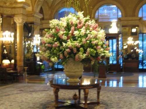 A large vase filled with pink and white flowers sits on a table