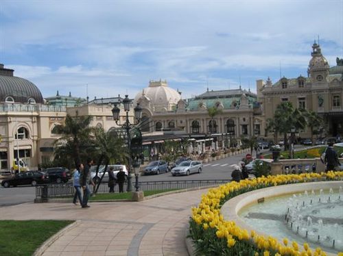 A fountain with yellow flowers in front of a large building