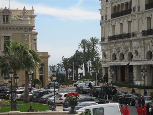 A white van is parked in front of a large building