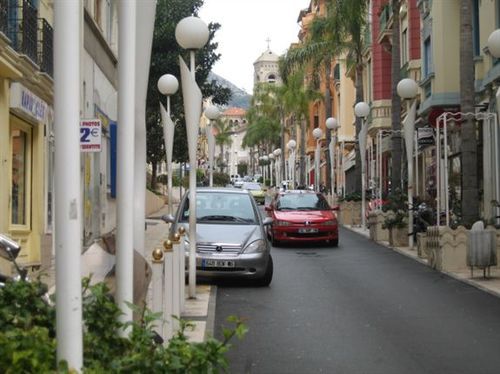 A row of cars are parked on a street with a sign that says 2 on it