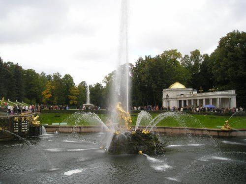 A fountain in a park with a building in the background