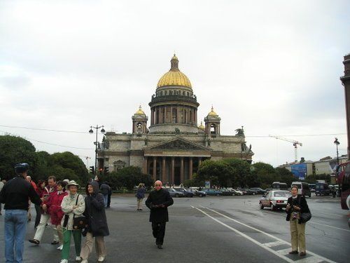 A group of people walking in front of a large building