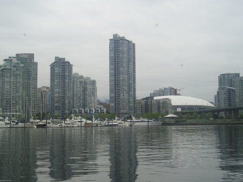 A city skyline is reflected in a body of water