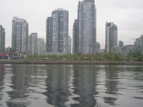 A city skyline is reflected in a body of water