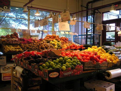A variety of fruits and vegetables are displayed in a grocery store